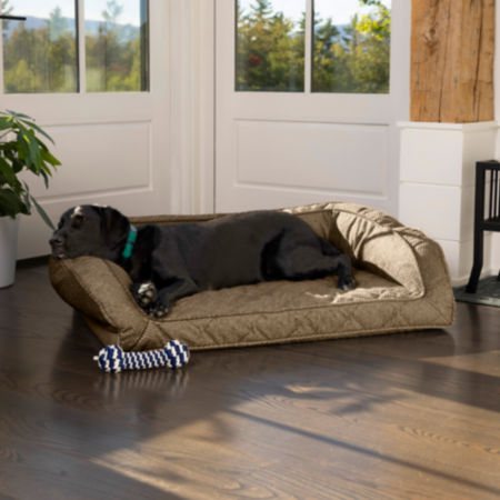 A black dog asleep in a dog bed inside a house