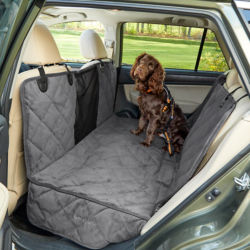 A dog sitting in the back seat of a car on a Grip-Tight® Windowed Hammock Seat Protector