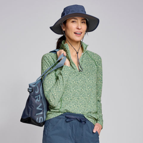 Model wearing drirelease® Long-Sleeved Quarter-Zip Tee in pale green abstract, naval blue Solar Roller Sun Hat, and All-Around Relaxed Fit 8" Shorts in deep ocean.
