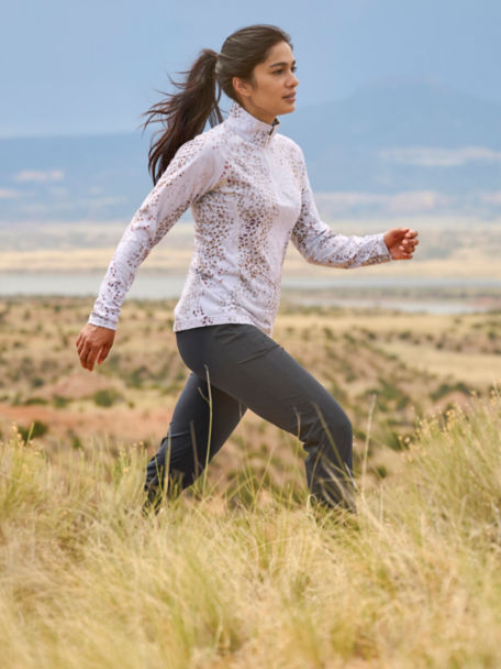 Woman in Wonder Ripstop Natural Fit Joggers walks through tall grass in the desert.
