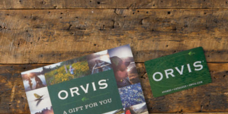 Orvis gift cards arranged on a wood background