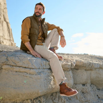 Man in Ultimate Khakis sits on the edge of a rocky cliff.