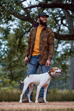 Durrell Smith with one of his dogs stand under a live oak tree