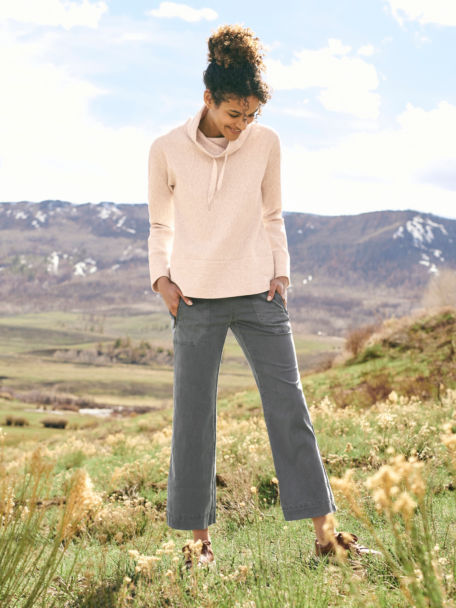 Woman in Explorer Natural Ankle Pant and Oceana Textured Cowl Sweatshirt poses on a desert trail.