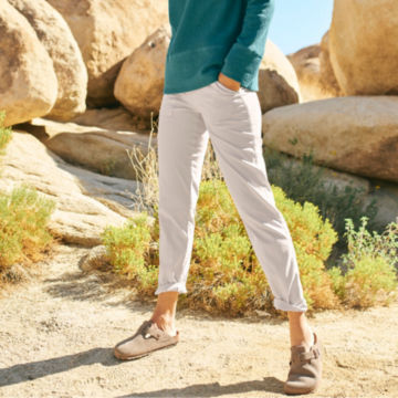 Woman in White Explorer Natural Fit Straight-Leg Ankle Pants walks through the desert.