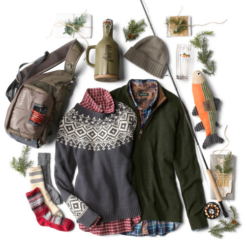 A men's and women's sweater with an assortment other gifts like a fly rod and cozy socks