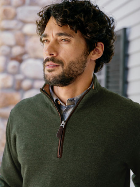 Man wears a quarter zip wool sweater