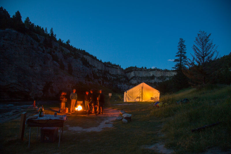 People standing around a campfire in the mountains of Montana.