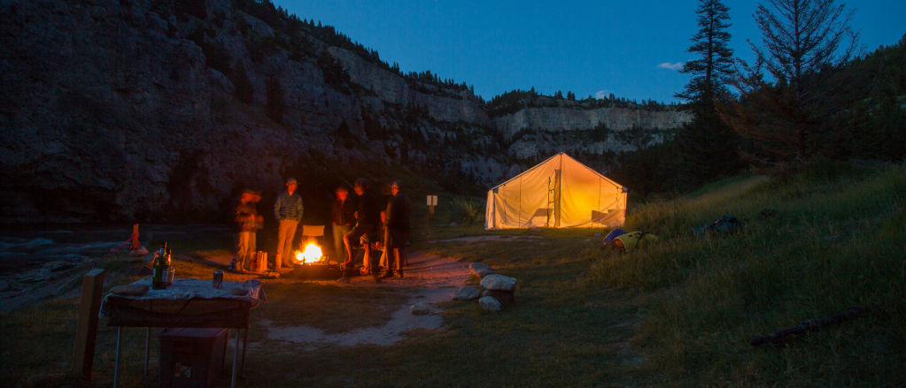 People standing around a campfire in the mountains of Montana.