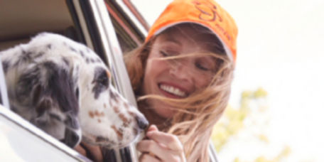 Woman pokes her head out of the window to admire her dog
