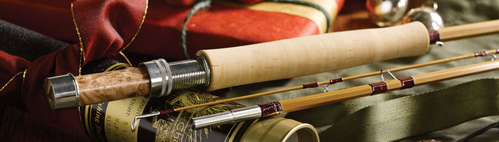 A bamboo fly rod leaning on its ornate metal tube