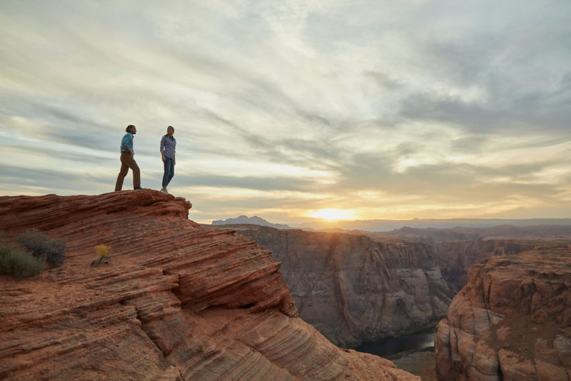 Two people standing on a cliff near Horsehoe Bend Overlook in Arizona