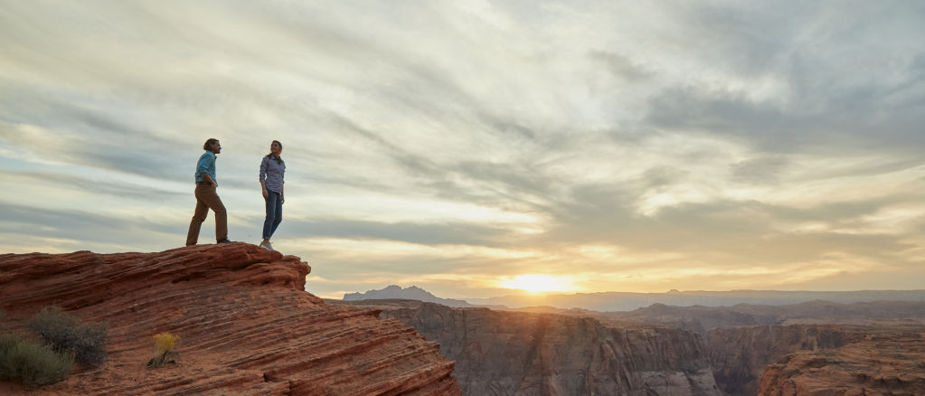Two people standing on a cliff near Horsehoe Bend Overlook in Arizona