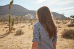 A woman in checkered shirt in the desert
