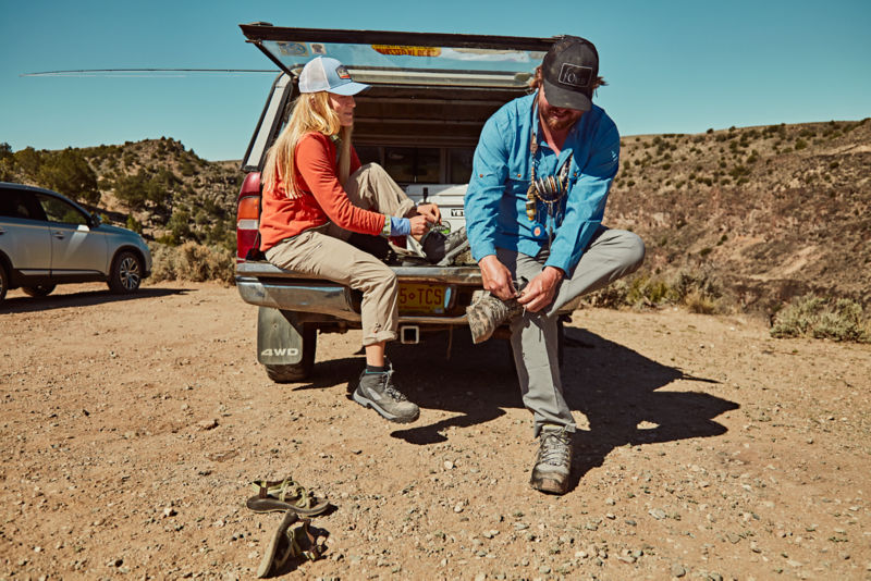 Woman and her fishing partner lace up their Ultralight Wading Boots in back of truckbed.