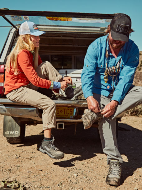 Woman and her fishing partner lace up their Ultralight Wading Boots in back of truckbed.