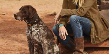 A woman kneeling on the dirt with her German Short-Haired Pointer.