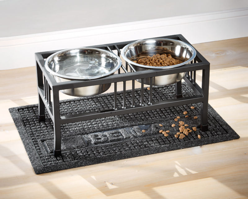 A metal stand holding two bowls, one with water, one with dry dog food.