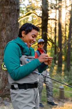 Woman tying a fly onto her fishing line