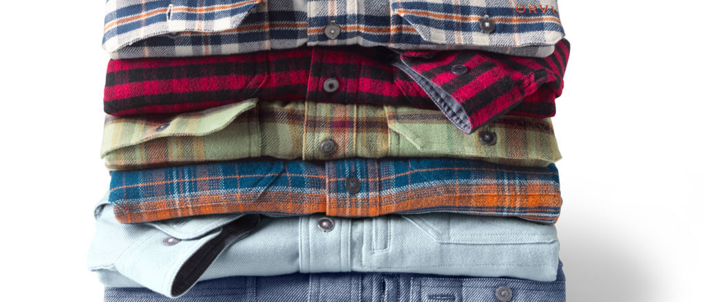 A close-up of a stack of Orvis Flannel shirts