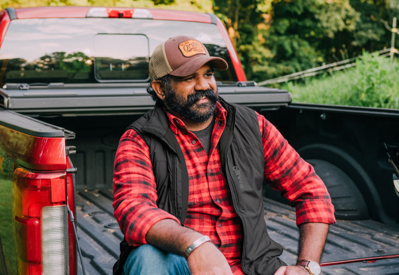 Sav Sankaran sitting in the bed of a pickup truck.