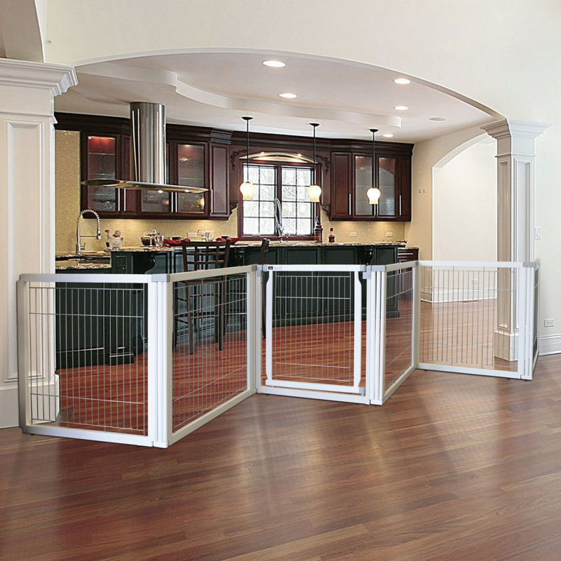 A large, folding dog gate blocking off a wide kitchen