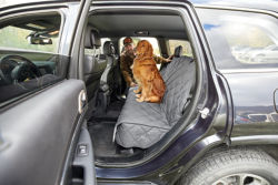 A golden Retriever sitting in the back seat on a Grip-Tight® Quilted Hose-Off Backseat Protector