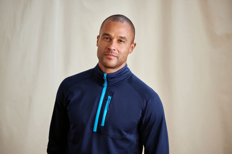 A waist-up view of a model wearing a navy quarter-zip sweatshirt.