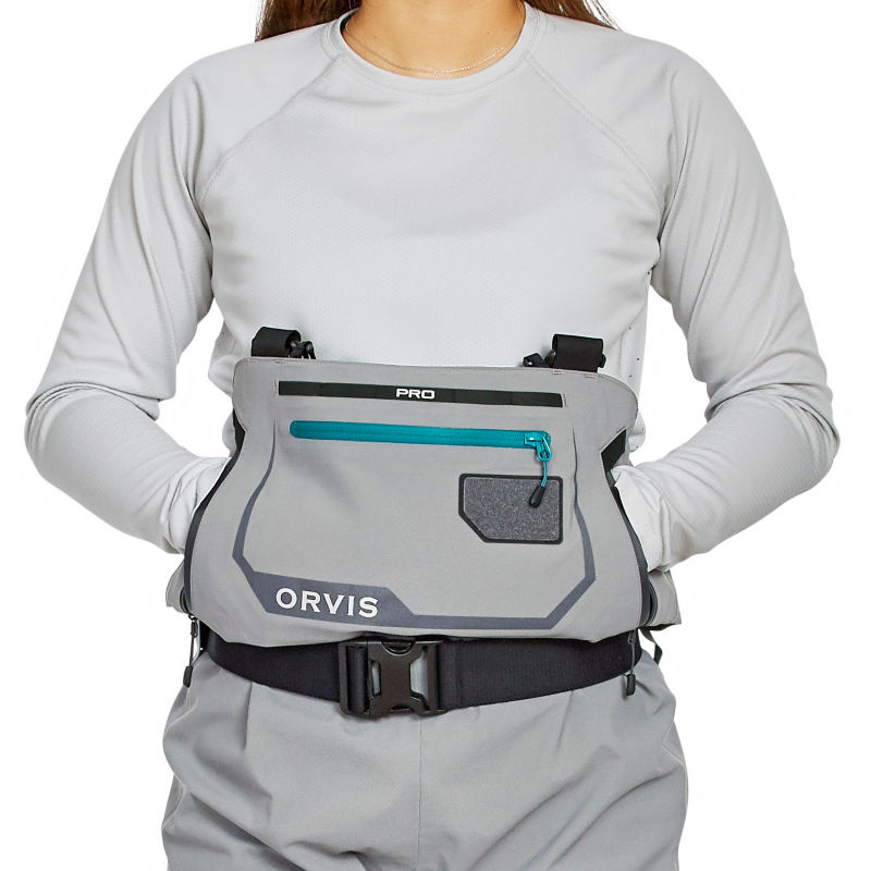 An angler tucks their hands into the warming pocket of their PRO waders.