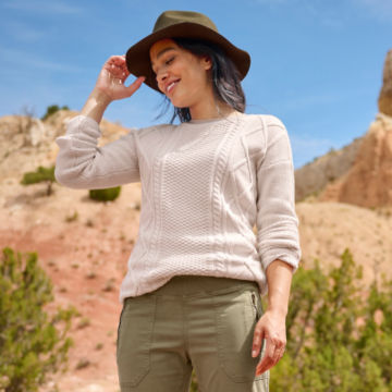 Woman in Cotton Cable Crewneck Sweater walks through the desert.