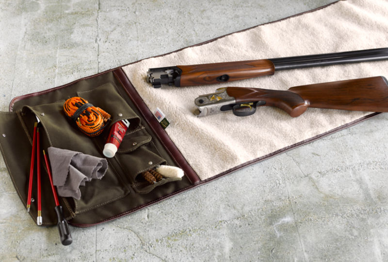 A disassembled shotgun laid out for cleaning.