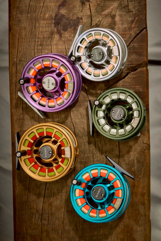 A collection of fly reels laid against a wooden background.