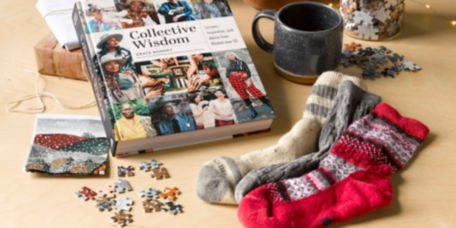 A collection of holiday gifts including a puzzle and mug, socks and a book