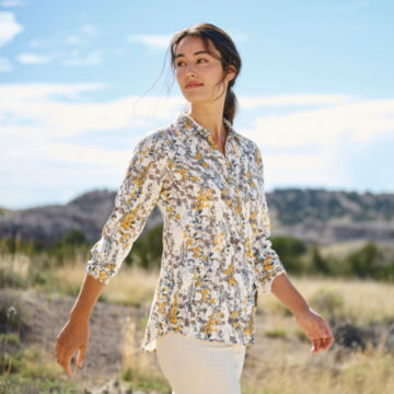 Woman in Long-Sleeved Everyday Silk Shirt walks out into a grassy desert.