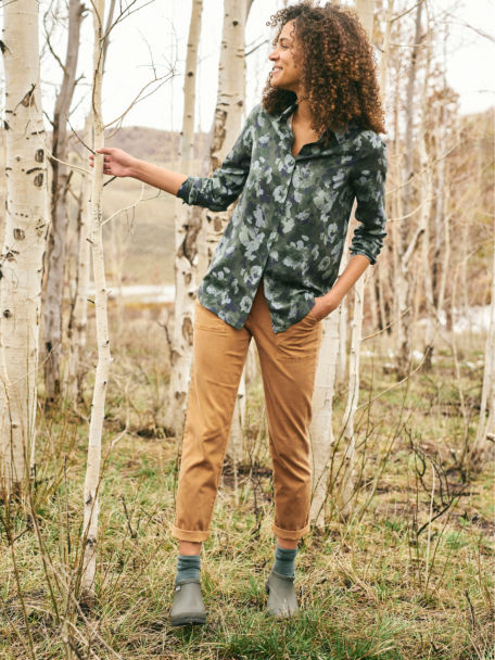Woman in Olive Camo Floral Long-Sleeved Everyday Silk Shirt walks among birch trees.
