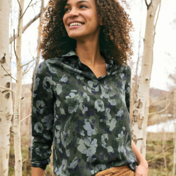 Woman in Everyday Printed Silk Shirt walks amongst birch trees.