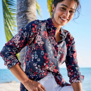 Woman in Everyday Printed Silk Shirt leans agains a palm tree..