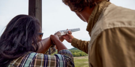 An instructor helping a student learn how to shoot