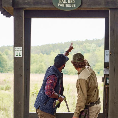 Two people discussing conditions at a shooting stand
