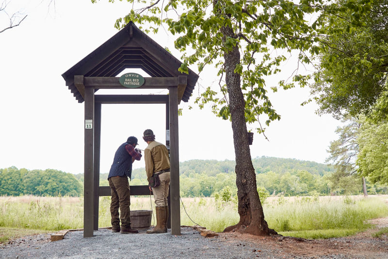 Two people take aim from a shooting stand