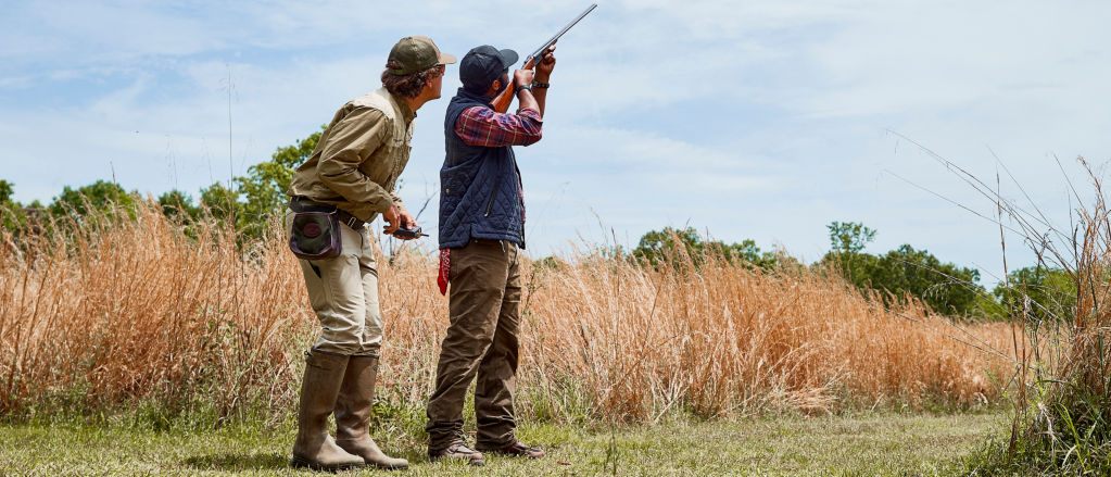 An instructor guides a shooting student in proper technique