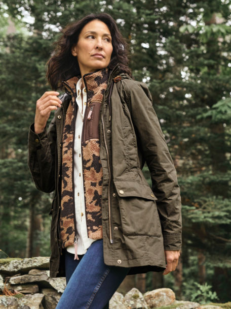 Woman in River Road Wax Cotton Jacket walking through the woods.