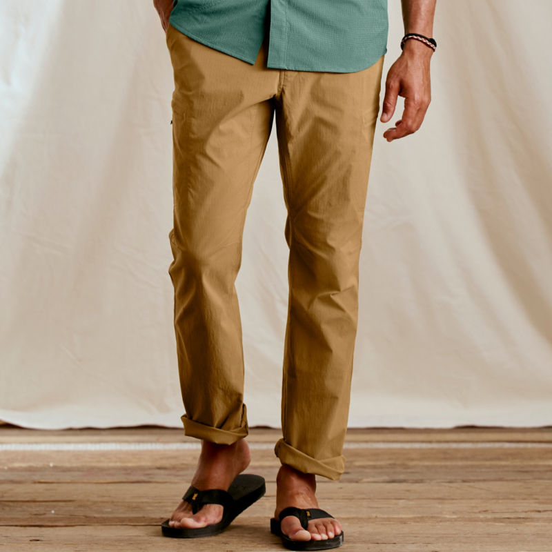 A waist-down view of a man wearing camel pants.