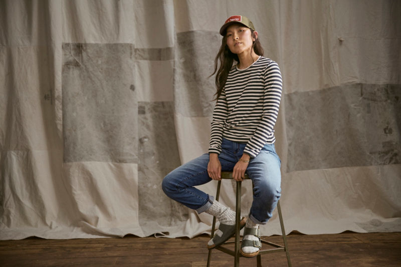 Woman sitting on stool with striped shirt on