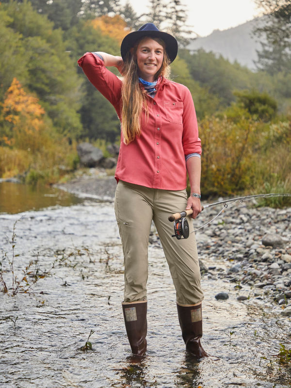 Kait Sampsel, posing, holding a fly rod and standing in a river