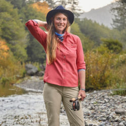 Kait Sampsel, posing, holding a fly rod and standing in a river