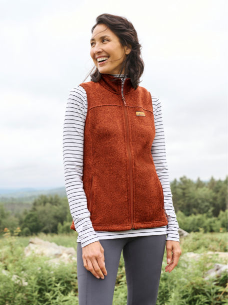 Woman in Bourbon R65™ Sweater Fleece Vest looks around the countryside as she stands on a hilltop.