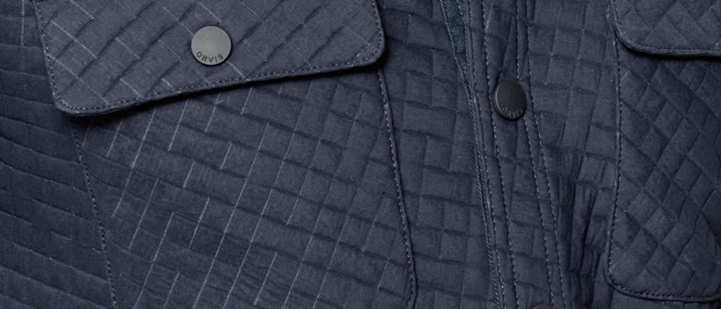 A close up image of 3D quilted fabric shows details such as pockets, stitching, and snaps