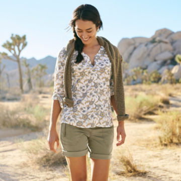 Woman in Easy Printed Long-Sleeved Camp Shirt walks down a desert trail.