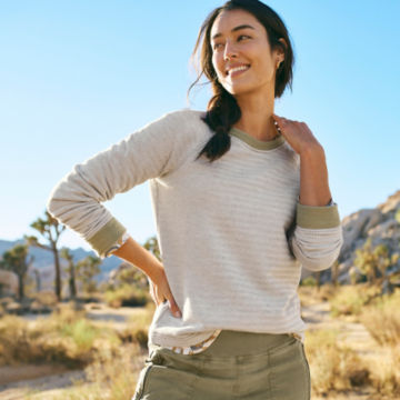 Woman in Safari Green Herringbone Crew Sweatshirt walks along a desert path.